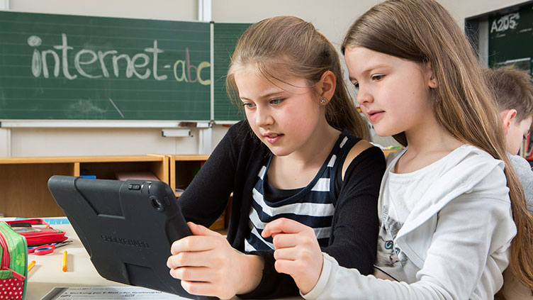 Mädchen in der Schule vor einem Tablet