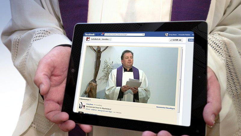 Titelbild: Von der Couch aus Gottesdienste live mitgestalten Pfarrer hält Tablet in seinen Händen